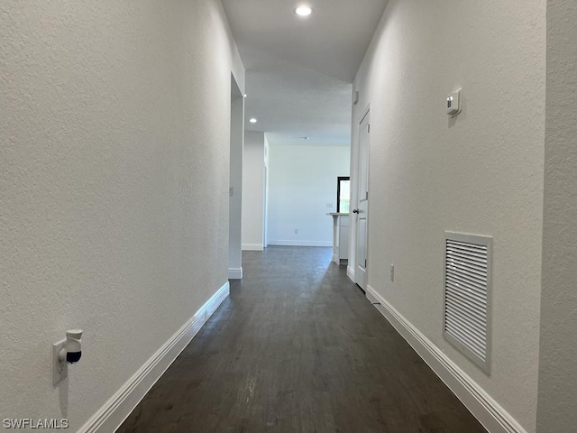 corridor with dark hardwood / wood-style flooring