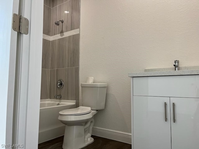 full bathroom with tiled shower / bath combo, toilet, wood-type flooring, and vanity