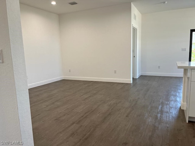 unfurnished room with dark wood-type flooring