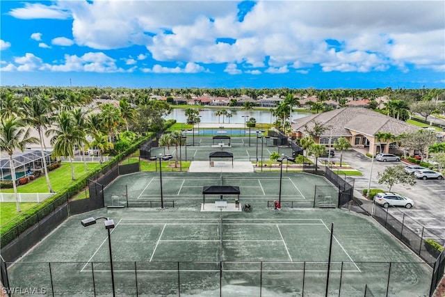 view of tennis court featuring a water view