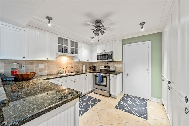 kitchen with sink, light tile patterned floors, stainless steel appliances, ornamental molding, and white cabinets