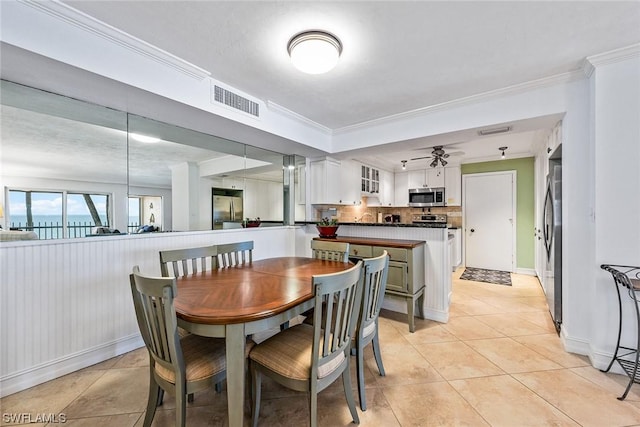 dining space featuring ornamental molding, light tile patterned floors, and ceiling fan