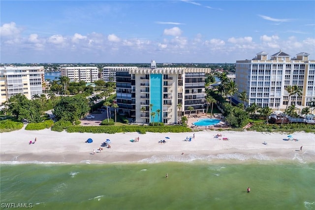 view of building exterior featuring a beach view and a water view