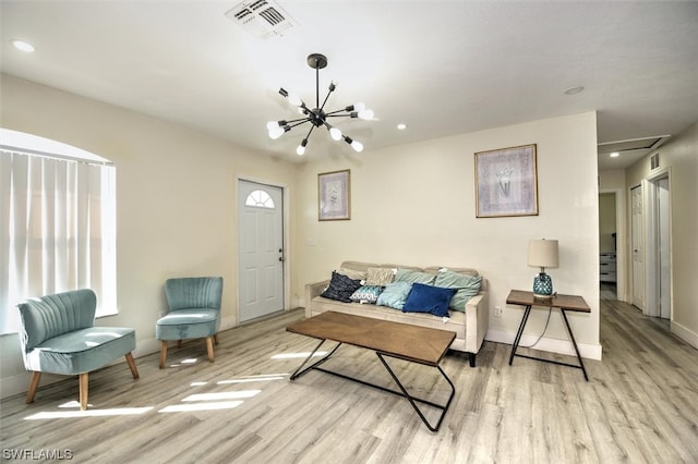 living room featuring a chandelier and light wood-type flooring