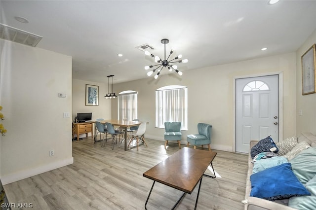 living room with a chandelier and light wood-type flooring