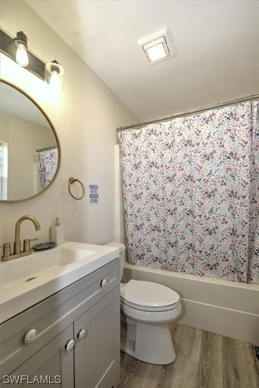 full bathroom featuring hardwood / wood-style flooring, toilet, shower / bath combination with curtain, and vanity