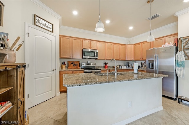 kitchen featuring a center island with sink, hanging light fixtures, light stone counters, and stainless steel appliances