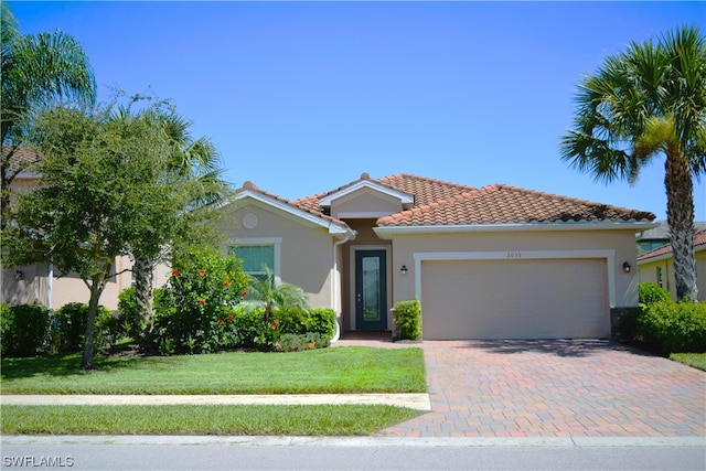 mediterranean / spanish-style house featuring a front yard and a garage