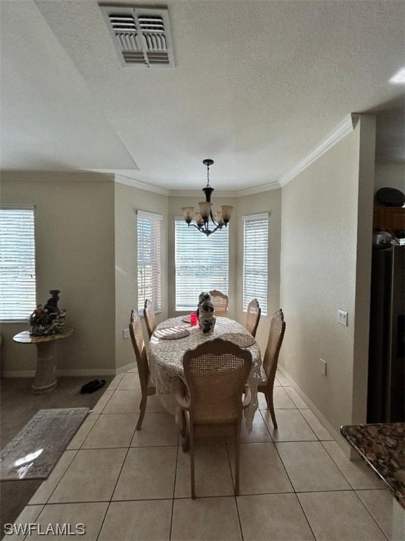 dining room with a notable chandelier, ornamental molding, and light tile floors