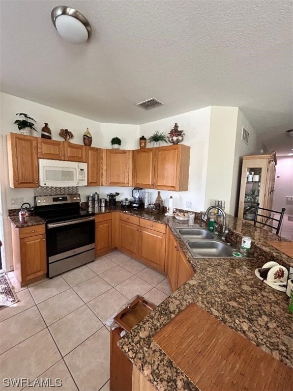 kitchen featuring a textured ceiling, kitchen peninsula, electric stove, sink, and light tile floors