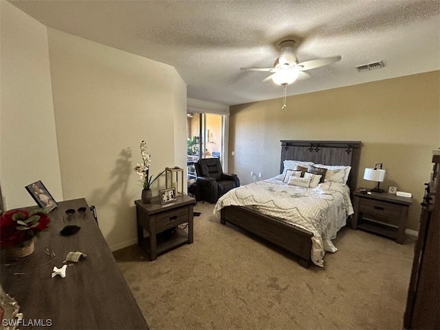 carpeted bedroom with ceiling fan and a textured ceiling