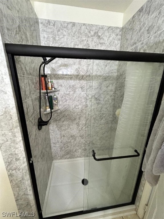 bathroom featuring a shower with door