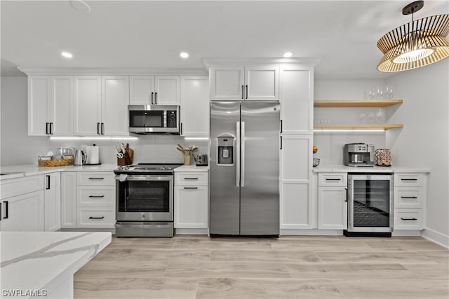 kitchen with beverage cooler, appliances with stainless steel finishes, white cabinets, light wood-type flooring, and light stone counters