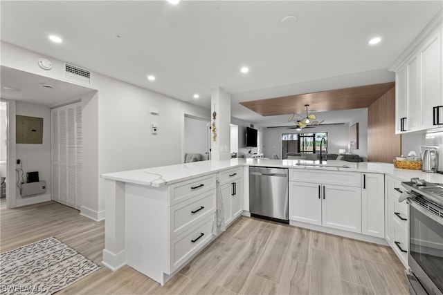 kitchen featuring stainless steel appliances, ceiling fan, kitchen peninsula, light wood-type flooring, and sink