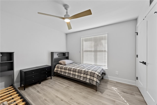 bedroom with a closet, ceiling fan, and light wood-type flooring