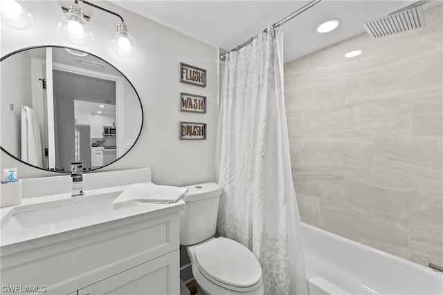 full bathroom featuring toilet, large vanity, and shower / tub combo