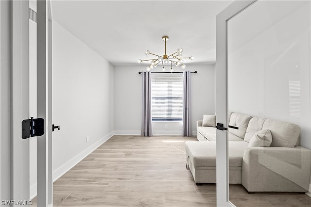 living room with light hardwood / wood-style flooring and an inviting chandelier