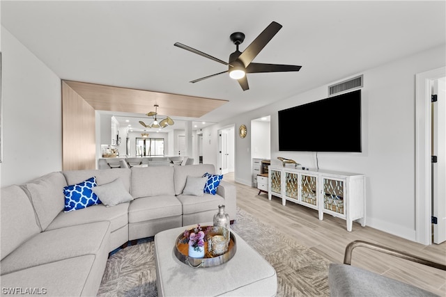 living room with light hardwood / wood-style floors and ceiling fan