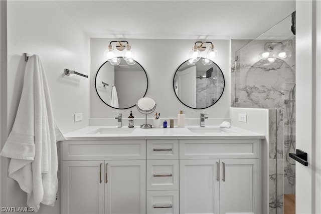 bathroom featuring double sink, a shower with shower door, and vanity with extensive cabinet space