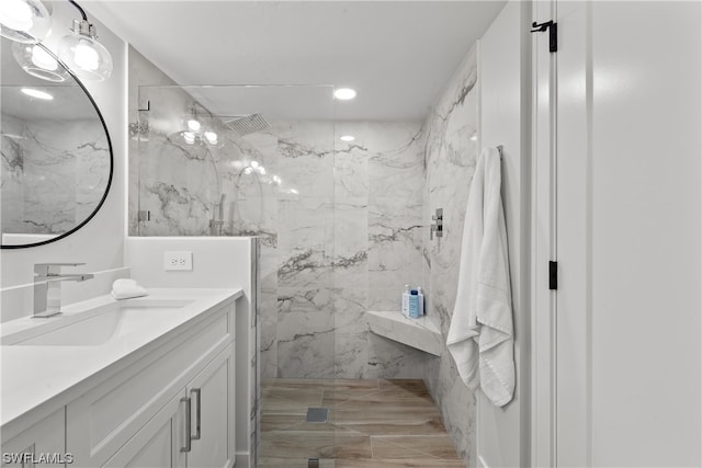 bathroom featuring large vanity and a tile shower