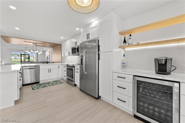 kitchen featuring white cabinets, beverage cooler, a notable chandelier, and stainless steel appliances