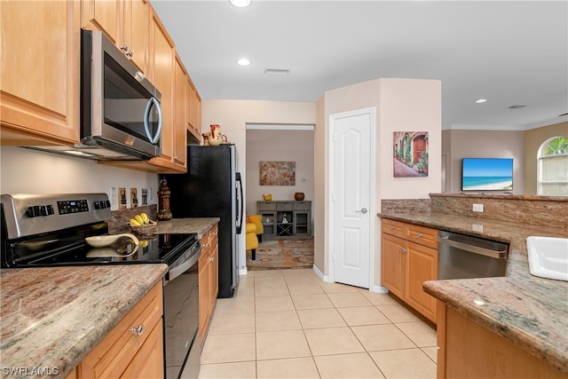 kitchen featuring light stone counters, appliances with stainless steel finishes, sink, and light tile floors