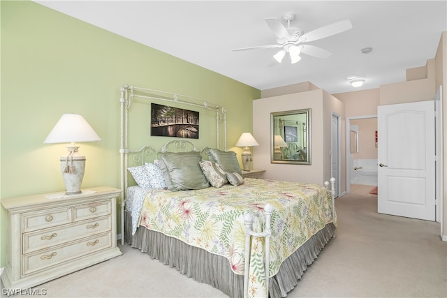 carpeted bedroom featuring ceiling fan and ensuite bath