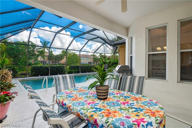 view of pool featuring a patio, glass enclosure, pool water feature, and ceiling fan