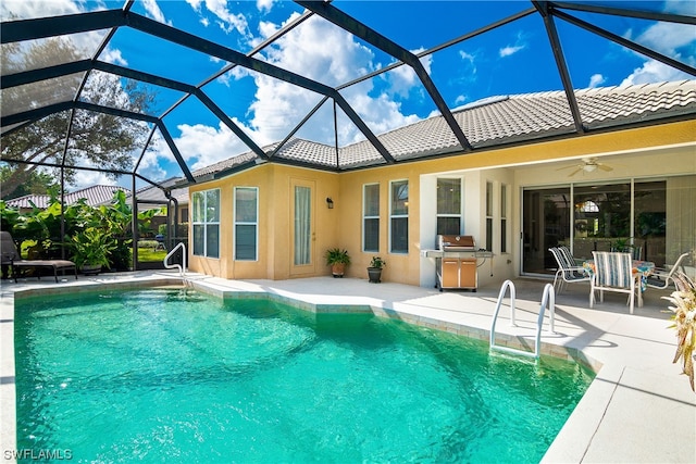 view of swimming pool featuring ceiling fan, a lanai, and a patio