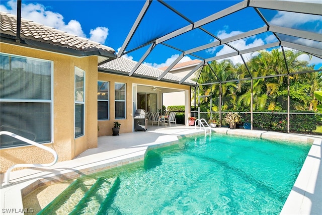 view of swimming pool featuring a grill, a patio, glass enclosure, and ceiling fan