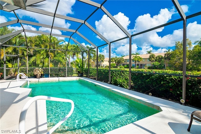 view of swimming pool featuring a patio and a lanai