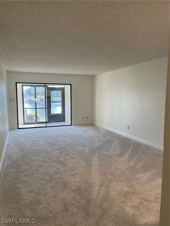 carpeted spare room featuring a textured ceiling