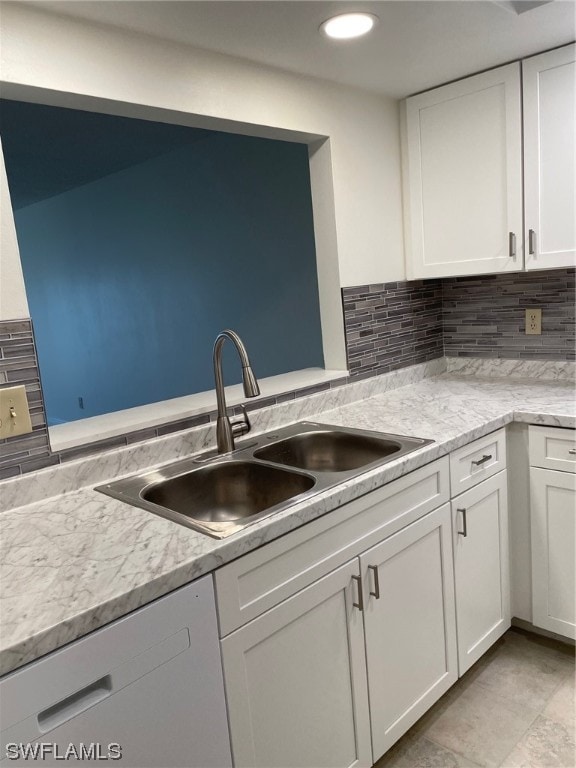 kitchen featuring light tile floors, white cabinets, tasteful backsplash, and sink