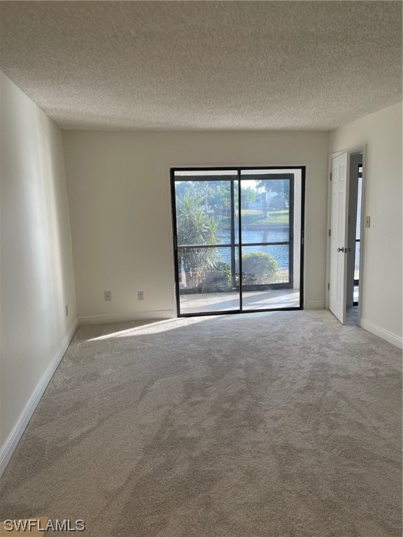 spare room with light carpet and a textured ceiling