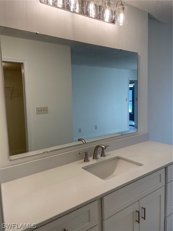 bathroom with a textured ceiling and vanity