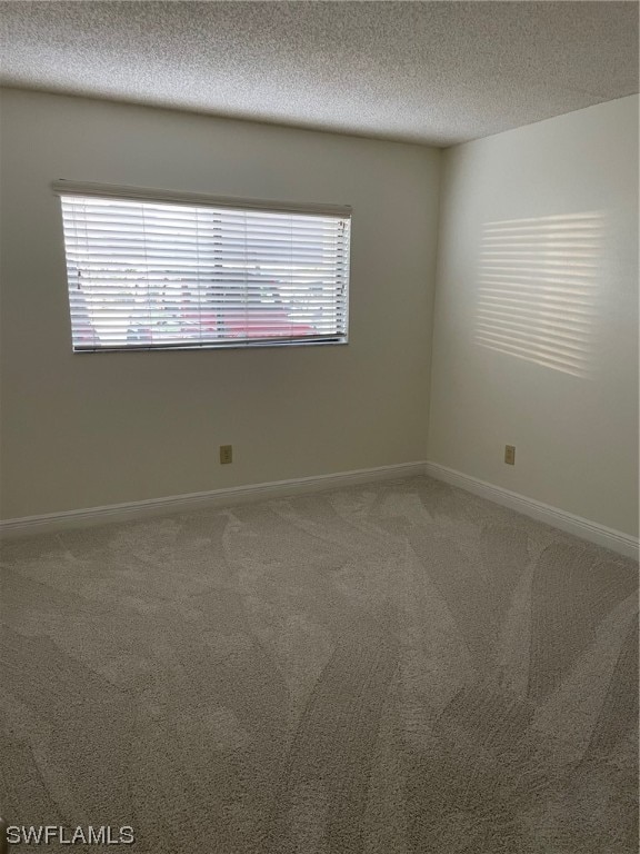 carpeted empty room featuring a textured ceiling