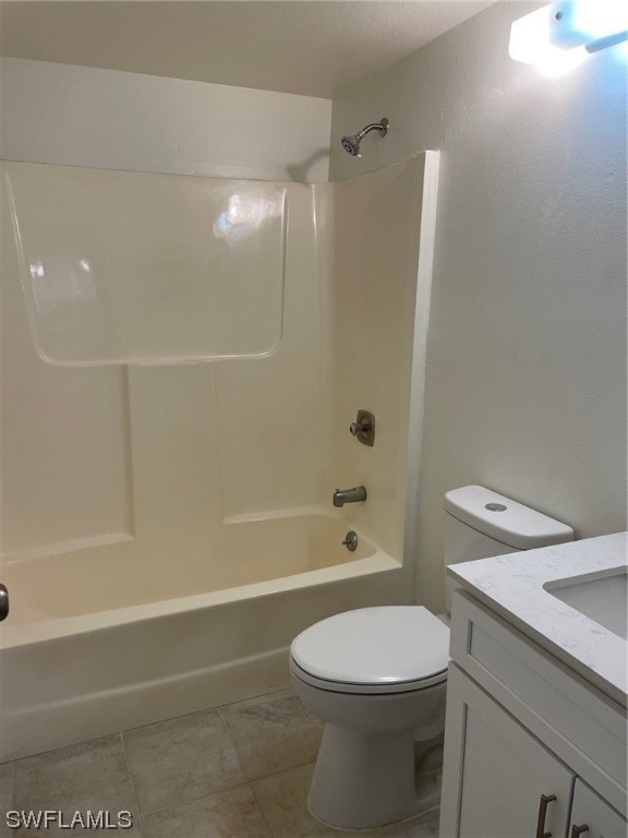 full bathroom featuring tile floors, toilet, vanity, and washtub / shower combination