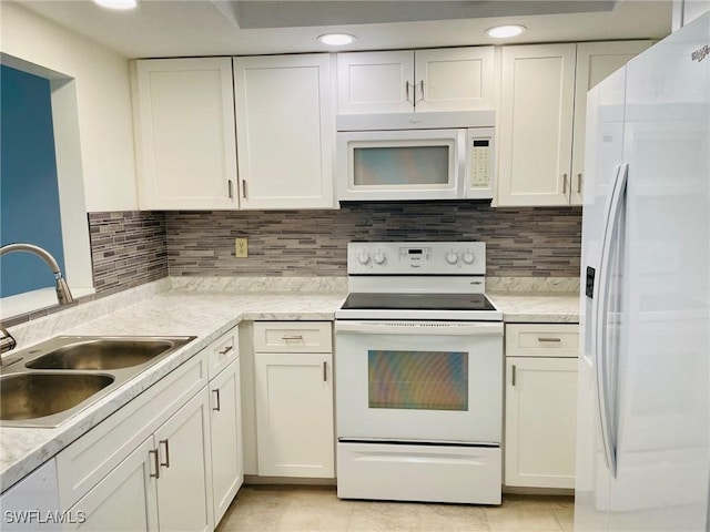 kitchen featuring recessed lighting, white appliances, a sink, white cabinetry, and tasteful backsplash