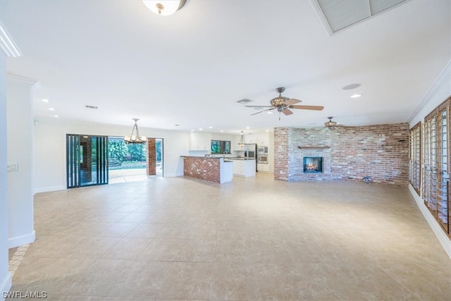 unfurnished living room featuring brick wall, a brick fireplace, ceiling fan with notable chandelier, crown molding, and light tile floors