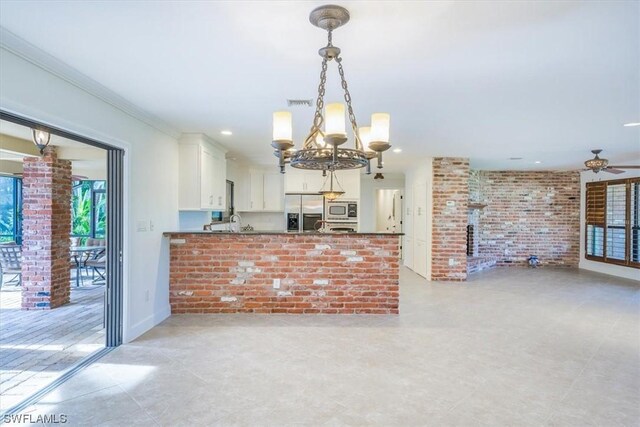 kitchen with kitchen peninsula, stainless steel appliances, ornamental molding, white cabinets, and pendant lighting