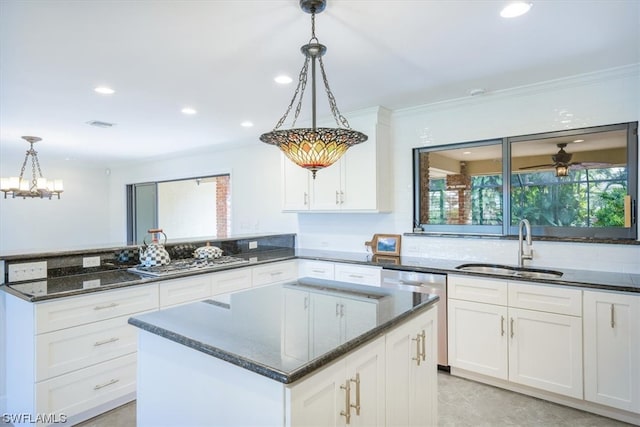 kitchen featuring dishwasher, sink, hanging light fixtures, and a kitchen island