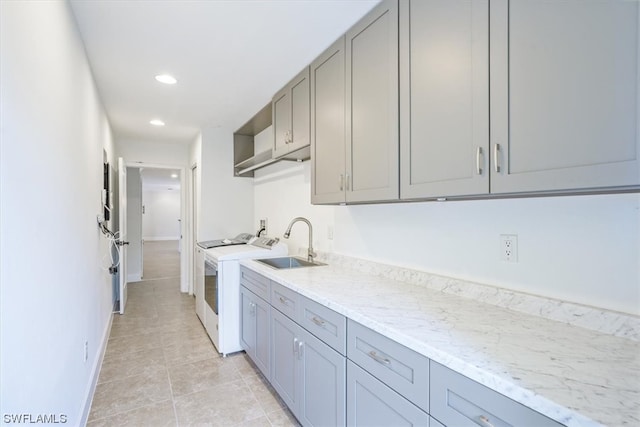 laundry room featuring sink, independent washer and dryer, and light tile floors