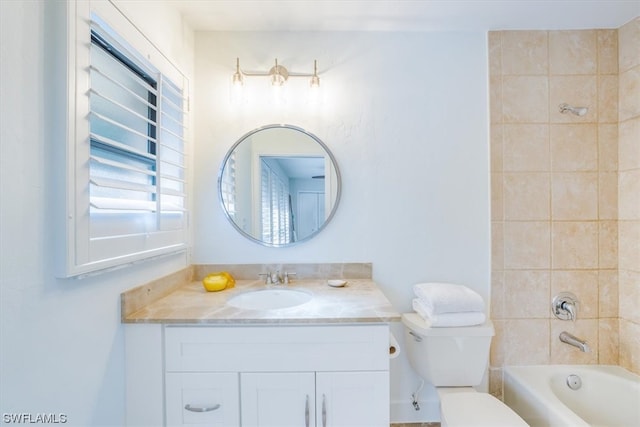 full bathroom with tiled shower / bath, toilet, and large vanity