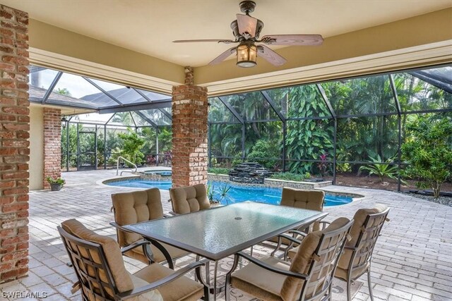 view of patio with glass enclosure, a swimming pool with hot tub, and ceiling fan