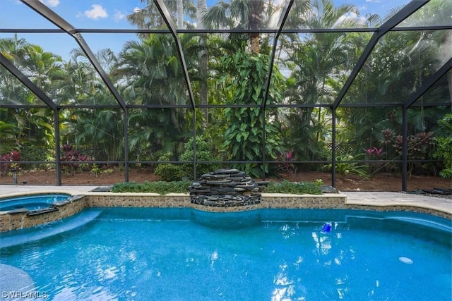 view of swimming pool featuring glass enclosure and an in ground hot tub