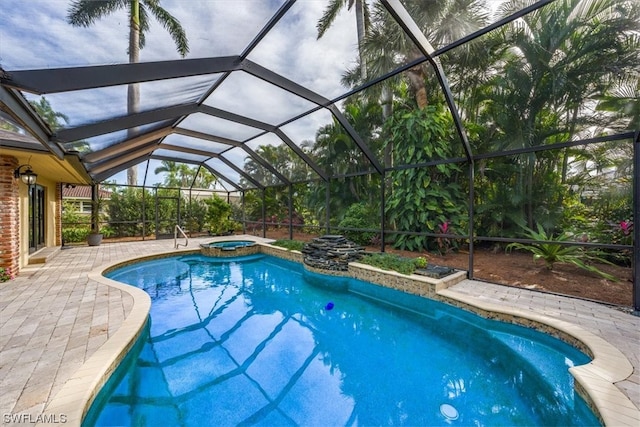 view of swimming pool with a patio, a lanai, and an in ground hot tub