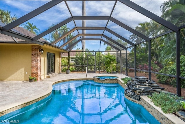 view of swimming pool featuring glass enclosure, an in ground hot tub, and a patio area