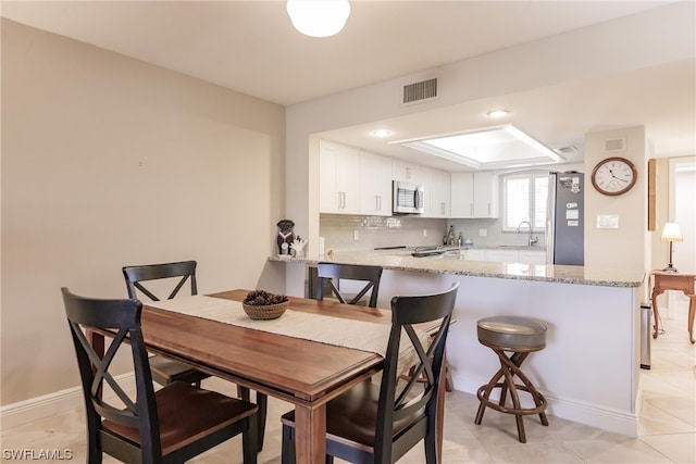 tiled dining room featuring sink