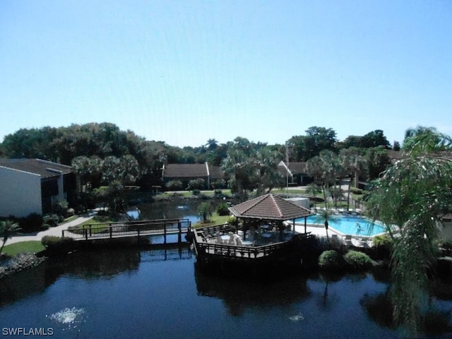 view of dock with a patio and a water view