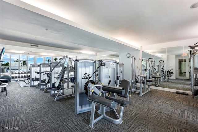 exercise room featuring dark carpet